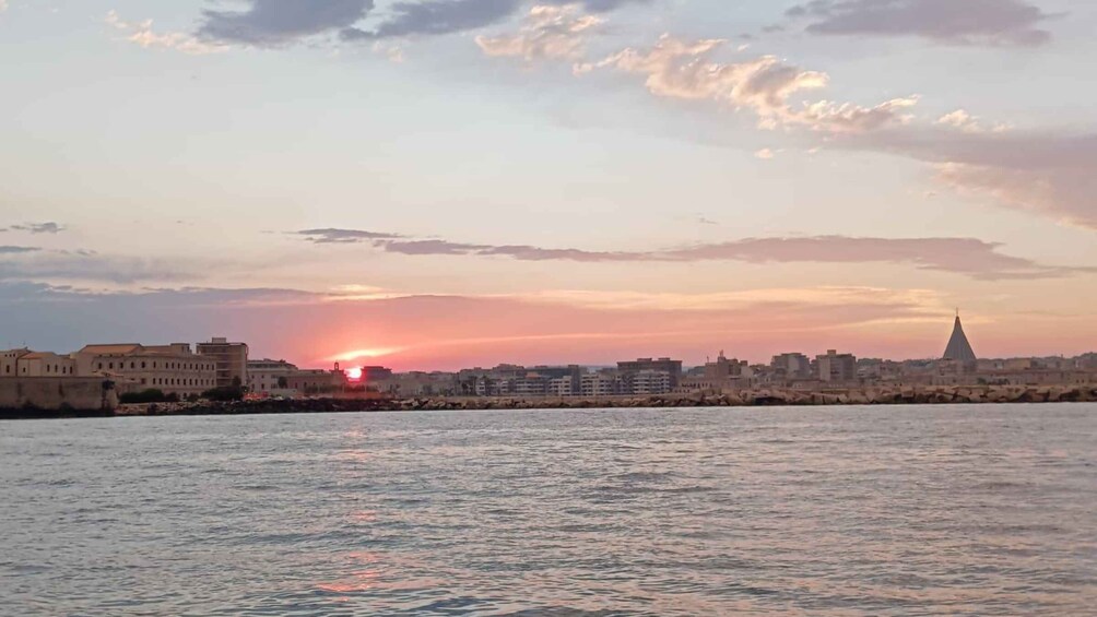 A sunset over a city skyline with a prominent church spire. 4