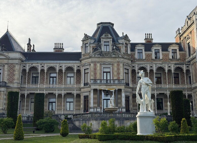 A grand historic building with ornate architecture, a central fountain, and statues. 1