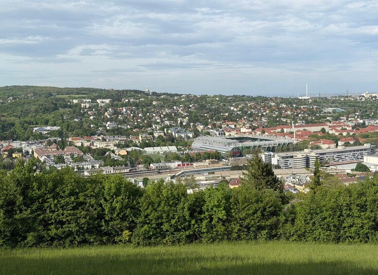 A cityscape with a prominent stadium, railway tracks, and a distant tower. 5