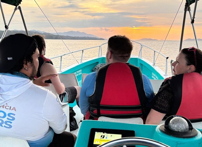 A boat with passengers wearing life jackets, a steering wheel, and a digital display. 4