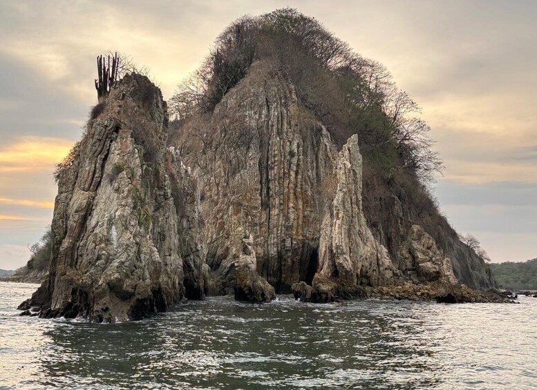 A large rock formation surrounded by water. 5