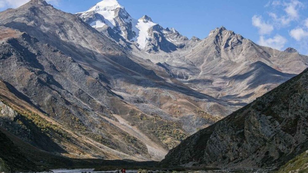 A mountain range with a snow-capped peak and a valley. 3