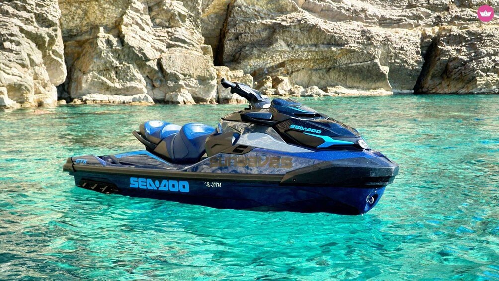 A blue Sea-Doo jet ski on clear turquoise water with rocky cliffs in the background. 3
