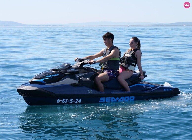 Two people on a Sea-Doo jet ski on a body of water with a distant shoreline. 1