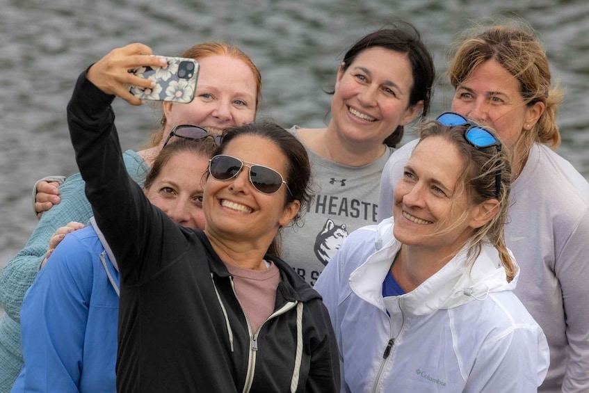 A group of people taking a selfie by a body of water. 3