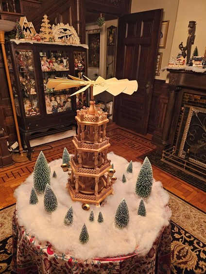 A multi-tiered wooden tower with a snow-covered base, surrounded by small Christmas trees and a flying toy. 1