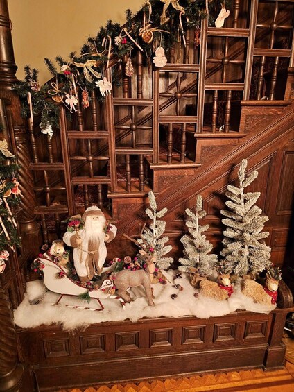 A decorated staircase with a Christmas scene, including a Santa Claus, reindeer, and snow-covered trees. 5