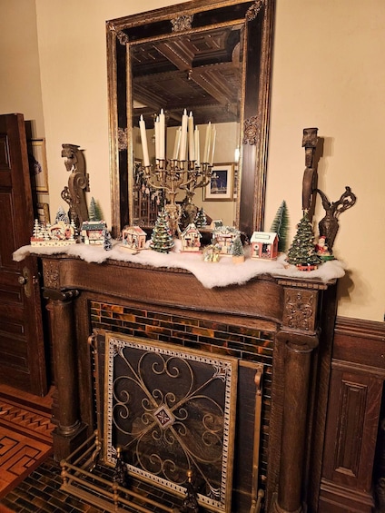 A fireplace mantel with a mirror, candles, and Christmas decorations. 5