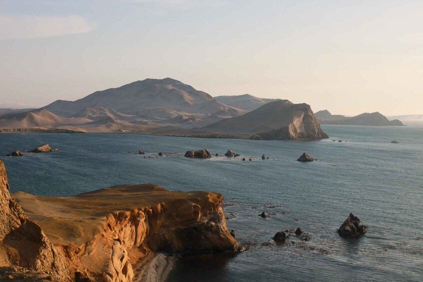 A coastal landscape with prominent cliffs and a calm sea. 5