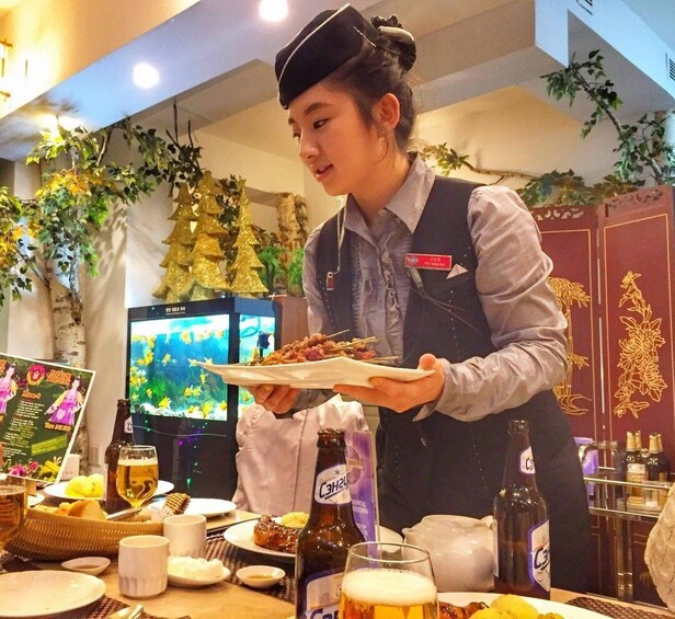 A person serving food at a restaurant with a TV in the background. 4