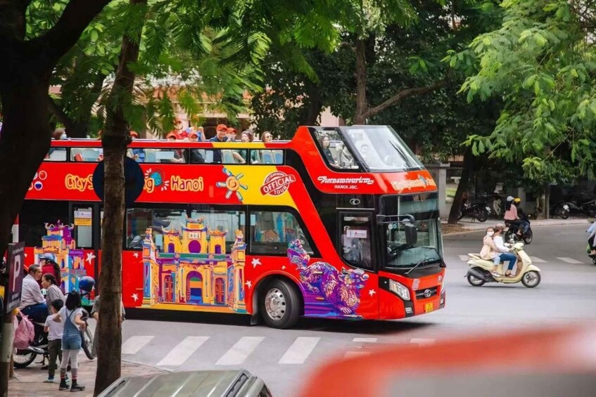 A double-decker bus with colorful murals and the text 'City Sightseeing Hanoi' on the side. 4