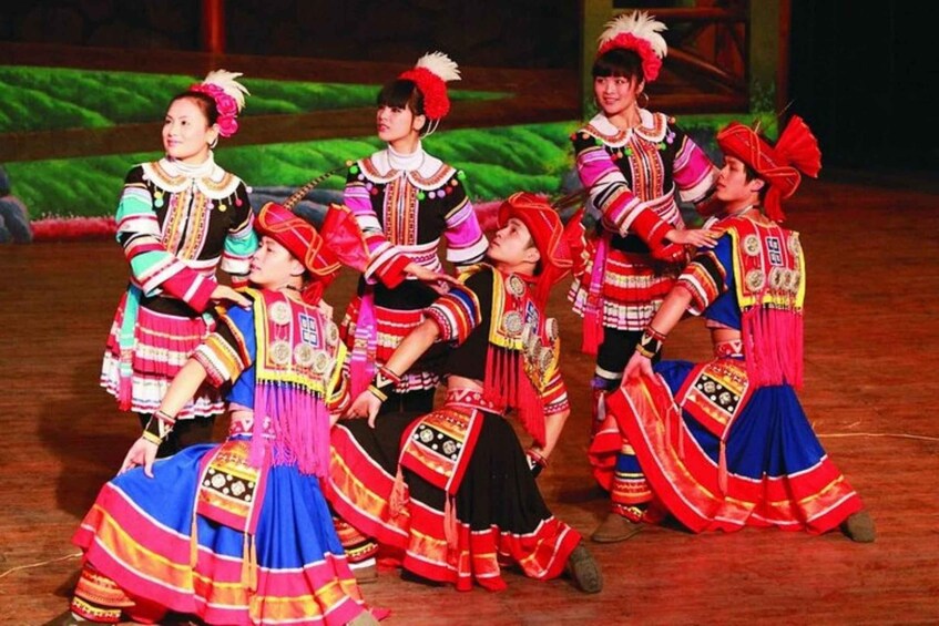 A group of performers in traditional costumes on a stage. 3