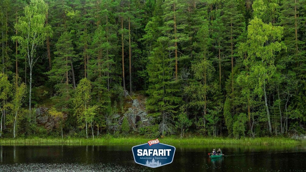 A dense forest with a lake, a logo for 'TAHKO SAFARIT' and a boat with two people. 3