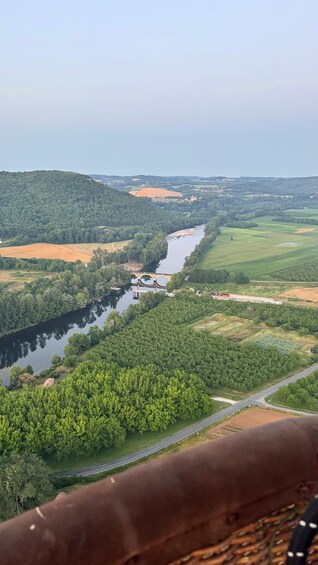 A river flowing through a valley with a bridge, surrounded by green fields and hills. 4