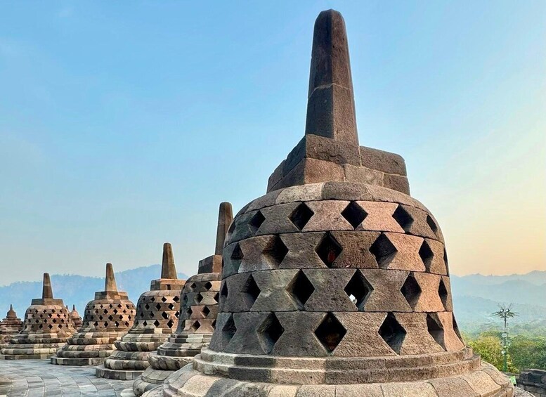 A series of stone structures with conical tops and diamond-shaped cutouts. 4