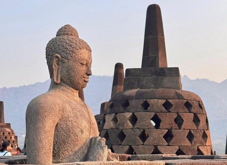 A stone Buddha statue with mountains in the background. 5
