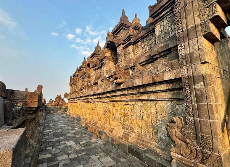 An ancient stone structure with intricate carvings and a paved pathway. 2