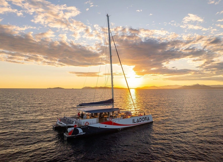 A sailboat named ILADORA on calm waters during sunset. 1