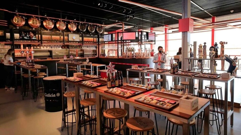 A restaurant interior with high ceilings, exposed ductwork, and a variety of seating options. 3