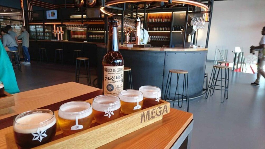 A bar with a bottle of beer and glasses on a wooden bar counter. 2