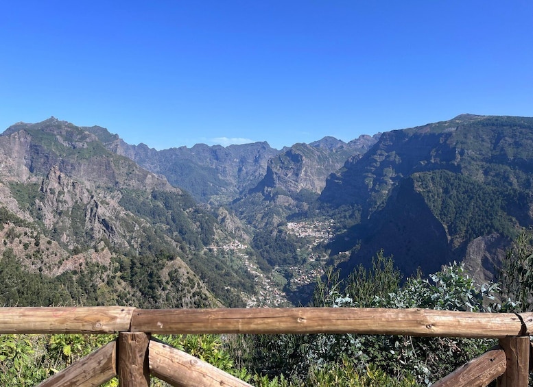 A mountainous landscape with a wooden fence in the foreground. 1