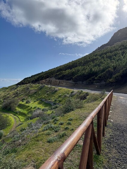 A wooden bridge over a rocky path with a mountainous backdrop and a clear sky. 2