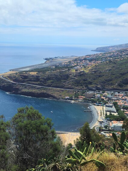 A coastal town with a beach, a road curving along the coast, and buildings in the background. 4