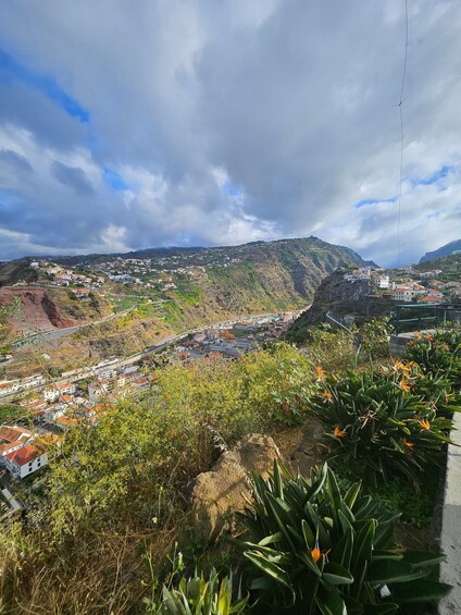 A coastal town with houses, a winding road, and a mountainous backdrop. 5