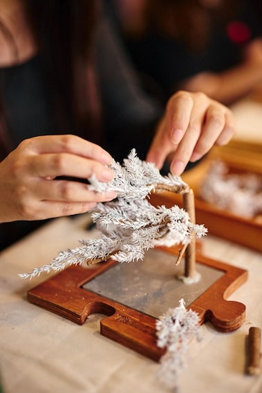 Hands assembling a wooden frame with a frosted glass piece. 5