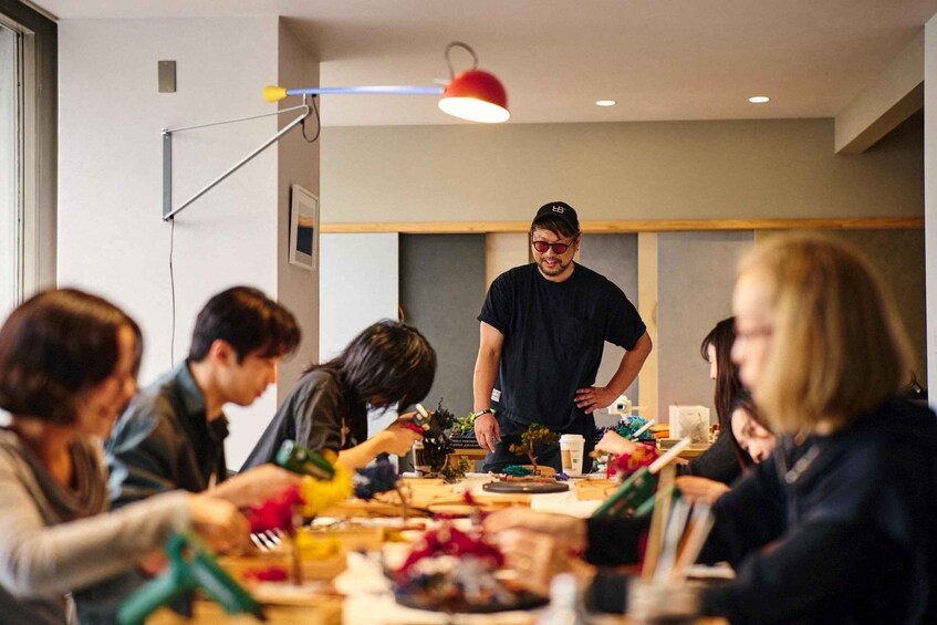 A group of people engaged in a craft activity around a table with various colorful materials. 3