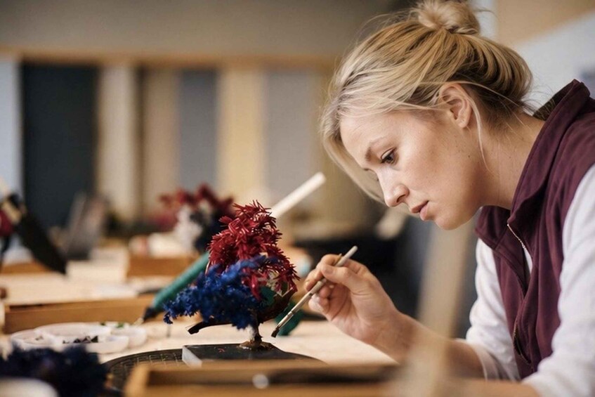 A person painting a colorful bird on a canvas. 1