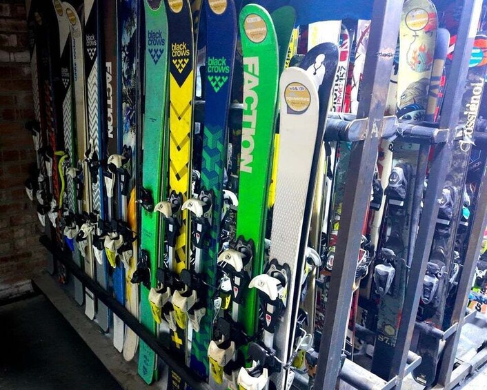 A rack of skis and ski boots in a shop. 2