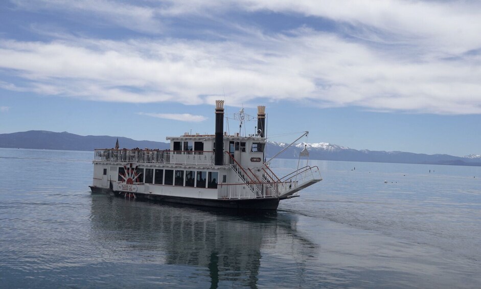 A stationary boat on calm water with a mountainous backdrop. 1