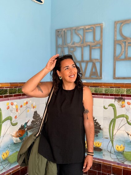 A person standing in front of a wall with a 'MUSEU DE ARTE' sign. 5