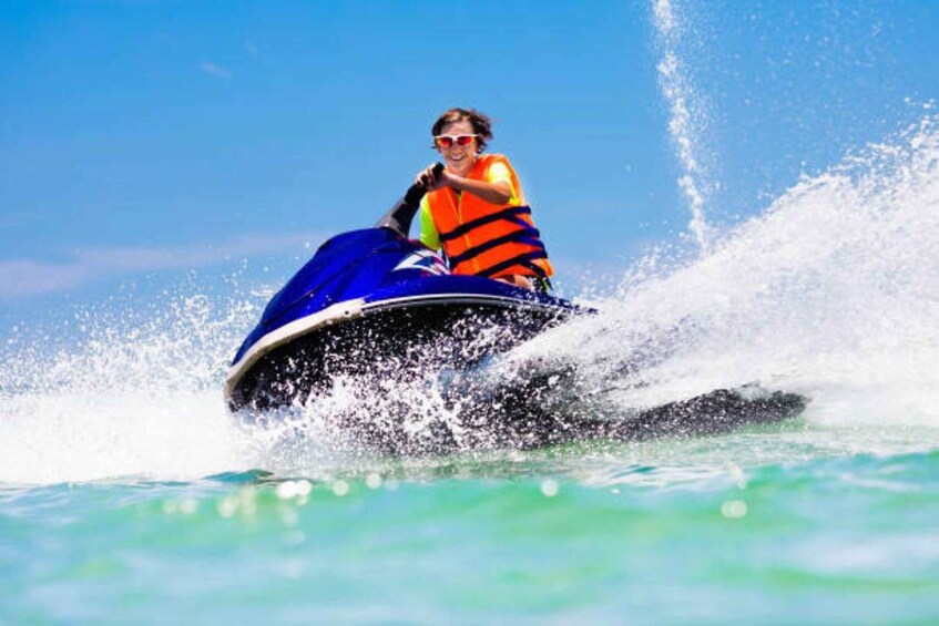 A person jet skiing on clear blue water. 2