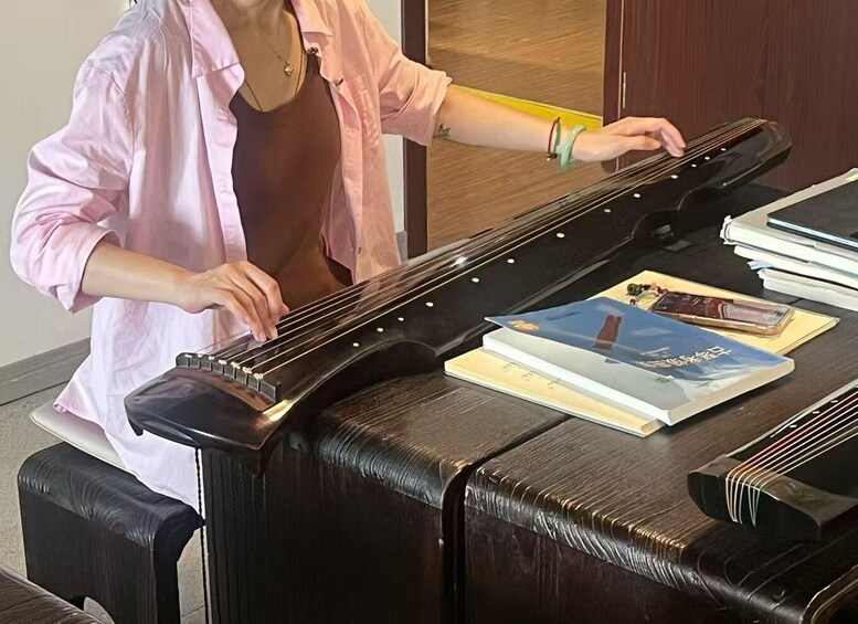 A person playing a zither at a piano. 3