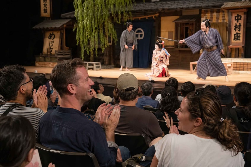 A traditional Japanese theater performance with actors in kimonos and a seated audience. 2