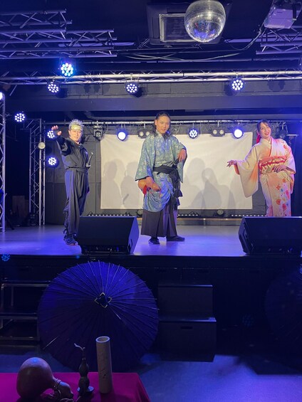 A stage with performers in traditional attire, a disco ball, and stage lighting. 5