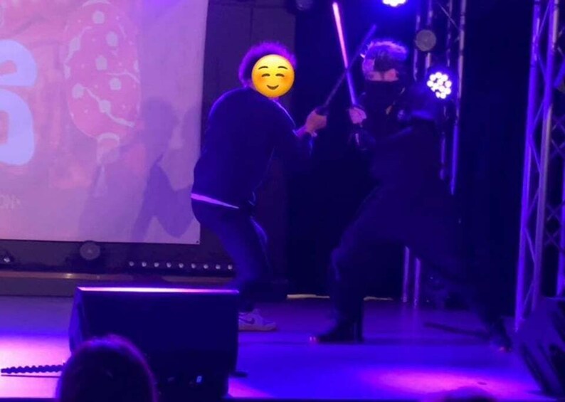 Two people on a stage with a large screen in the background. 5