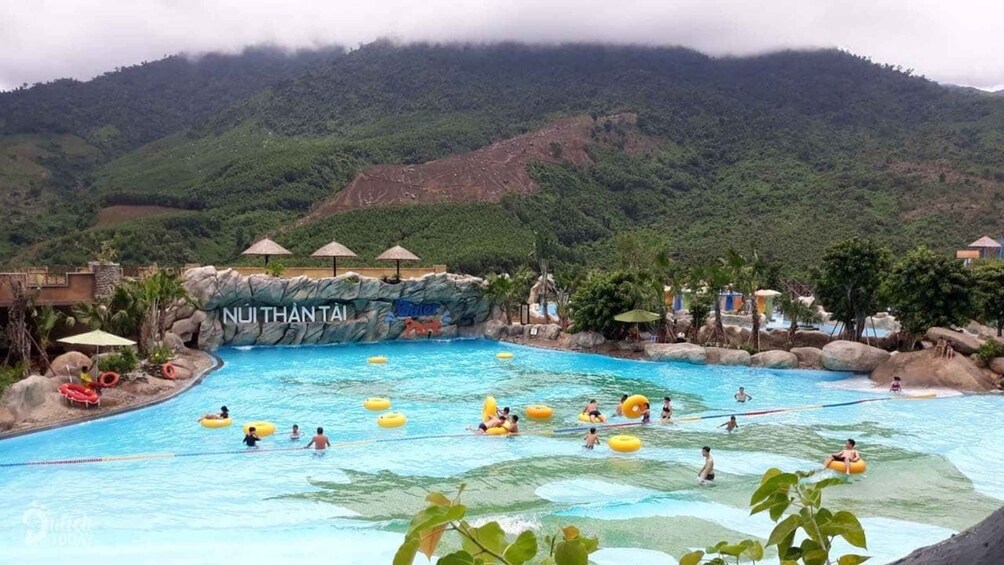 A water park with a pool, inflatable rings, and a mountain backdrop. 3