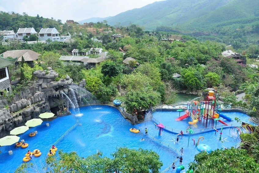 A water park with slides, a wave pool, and a mountainous backdrop. 2