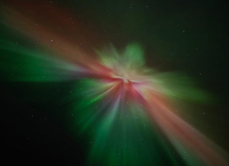 A starry night sky with a bright, colorful light source at the center. 2