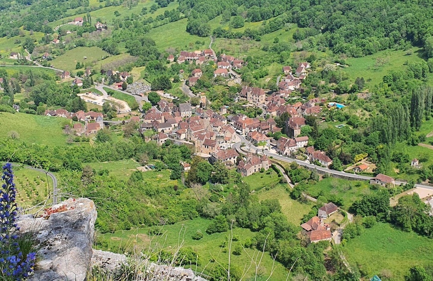 A village nestled in a valley surrounded by lush greenery and rolling hills. 5