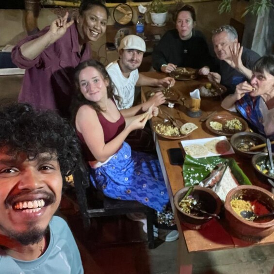 A group of people dining together at a wooden table with various dishes and utensils. 5