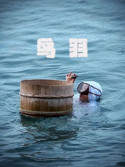 A person in a wooden barrel floating on water with a bag. 1