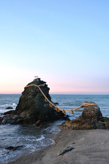 A rocky coastline with a rope bridge and a small structure on top. 5