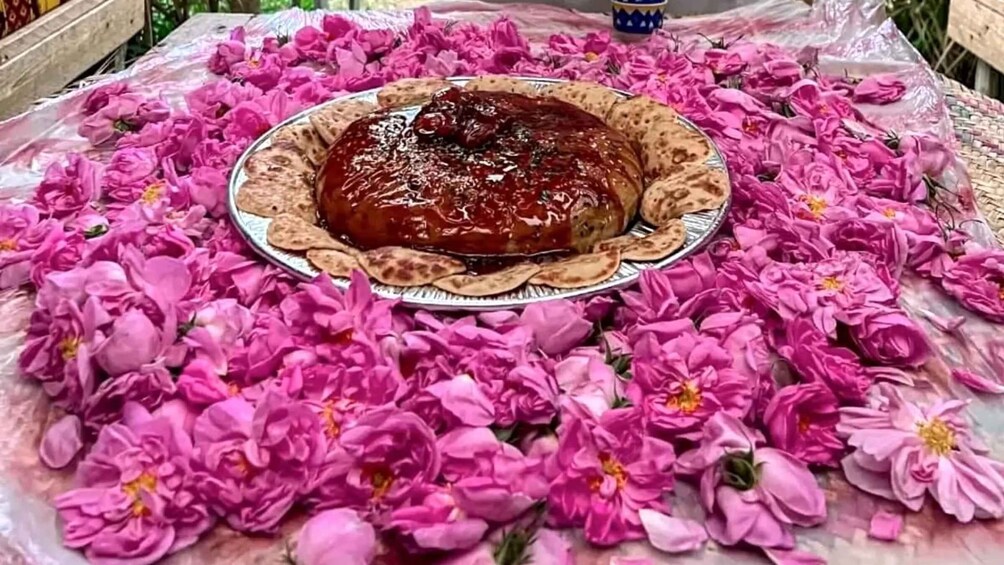 A dish of food on a plate surrounded by pink flowers. 5