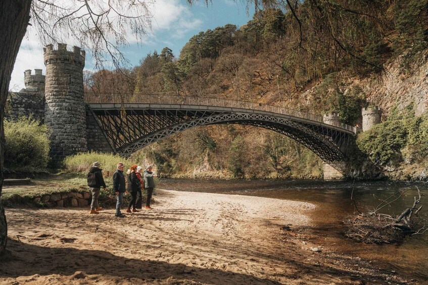 A stone bridge over a river, surrounded by trees and a castle-like structure. 2