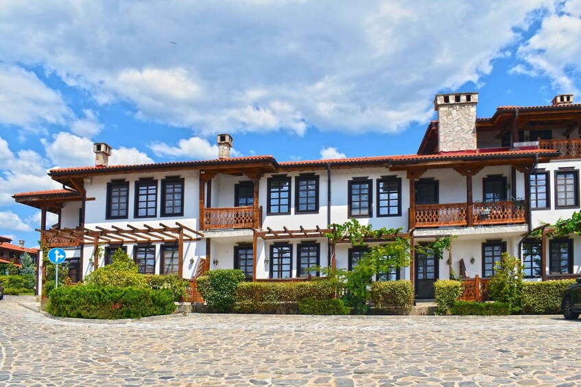 A traditional building with multiple balconies and a stone-paved courtyard. 1
