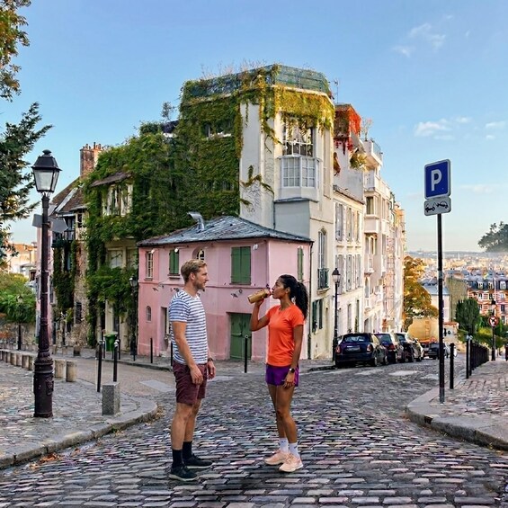 A cobblestone street with historic buildings, a street lamp, and a parking sign. 4